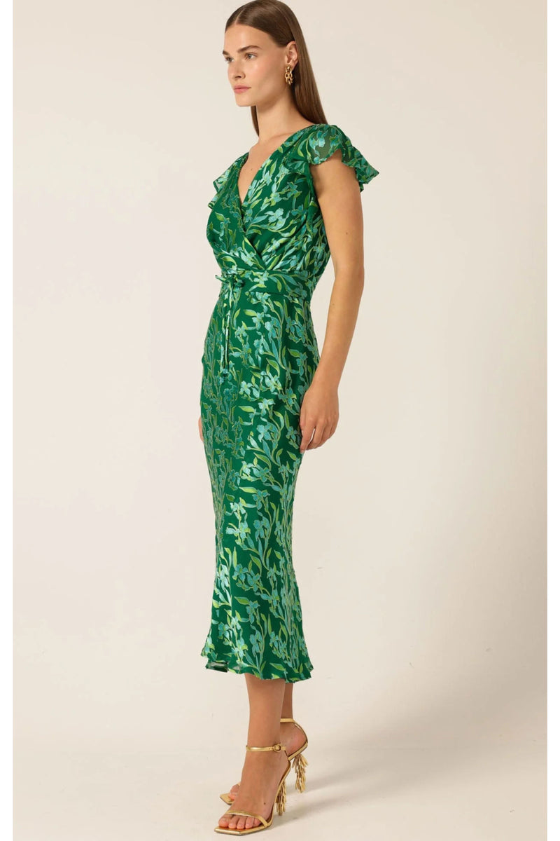 sacha drake green dress Fluid. Striking. Unforgettable. Our SACHA DRAKE exclusive green botanical print comes to life in two elegant silhouettes. Shop the Orchid Wrap Dress & Fleur De Lys Midi Dress online now. #sachadrake